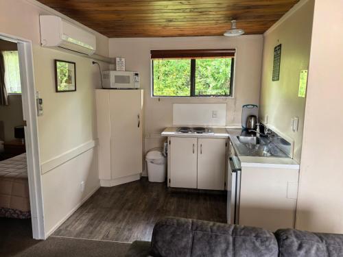 a small kitchen with a sink and a stove at Judges Pool Motel Turangi in Turangi