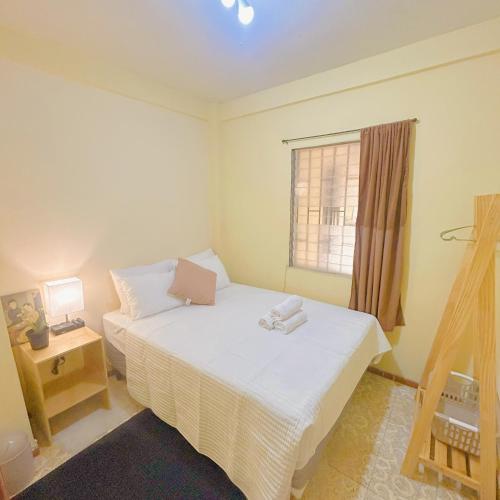 a small bedroom with a bed and a window at Uong Oasis in San Salvador