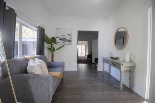 a living room with a couch and a table at Buninyong Golfside Getaway in Buninyong