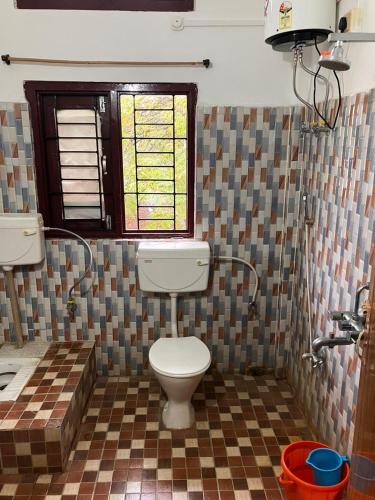 a bathroom with a toilet and a checkered floor at Green Stay , AC room in Sibsāgar