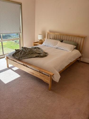 a bed with a wooden frame in a room with a window at Echucas Pawfect Accommodation - Dog Friendly in Echuca