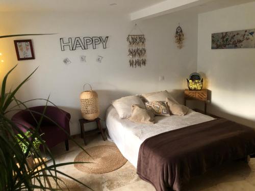 a bedroom with a bed with a happy sign on the wall at Natur eau Bulle in Ploufragan