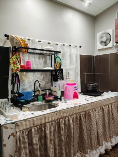 a kitchen with a sink and a counter top at Kampung Cottage Bagan Datuk in Selekoh