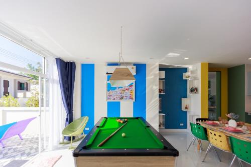 a pool table in a room with blue walls at Kanna Pool Villa in Chiang Mai