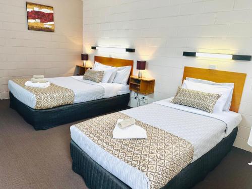 a hotel room with two beds and two lamps at Tartan Motel, Yea in Yea
