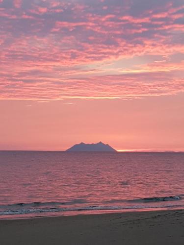 a view of the ocean with a mountain in the distance at Hotel Club Torre Capovento in Sperlonga