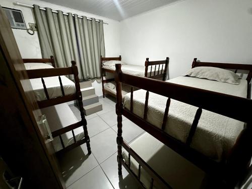 a room with three bunk beds and a window at Hostel Salazar in Campo Grande