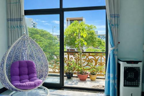 a hanging chair in front of a balcony with a window at Lộc Vừng Homestay in Phan Thiet
