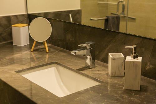 a bathroom with a sink and a mirror at Premium Apartment - Terraza Premium, Pool & Gym in Querétaro
