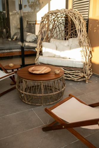 a room with a rattan chair and a couch at Premium Apartment - Terraza Premium, Pool & Gym in Querétaro