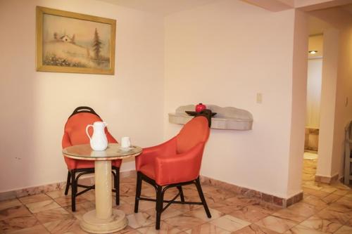 two chairs and a table in a room at Hotel Posada del Sol Inn in Torreón