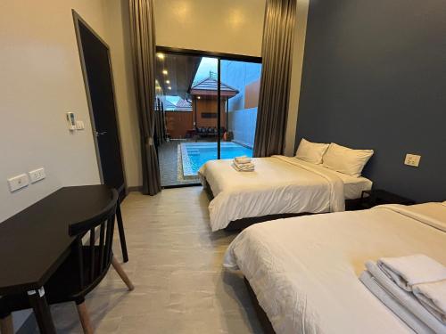 a hotel room with two beds and a balcony at Bluda Poolvilla A in Hat Yai