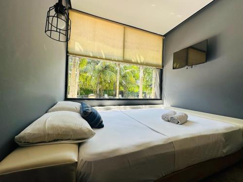 a bedroom with a large bed with a window at Bacalar 102 Hotel in Bacalar