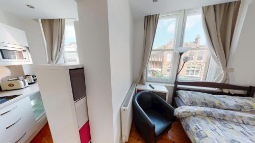a bedroom with a bed and a desk and a window at Corner View Studio Nottingham City Centre in Nottingham