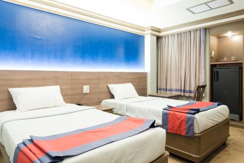 a hotel room with two beds and a large window at Bangkok Loft at Nana Station in Bangkok