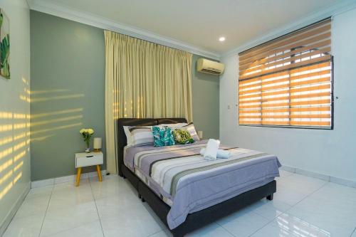 a bedroom with a bed and a window at Spacious 4BR Corner with Pool Table in Ipoh