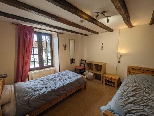 a bedroom with a bed and a window at Relais de la vallée de l'ource in Villars-Montroyer