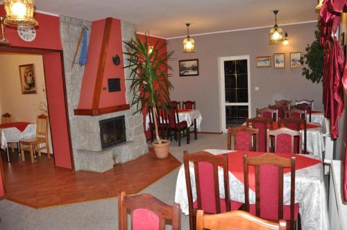 シュクラルスカ・ポレンバにあるWilla Onyksの暖炉、テーブル、椅子が備わるレストラン