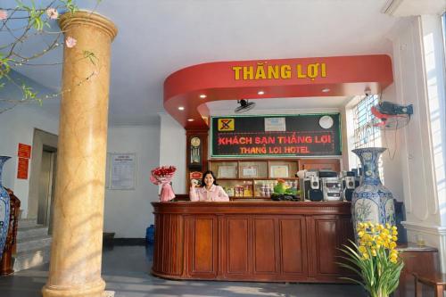 a woman standing at the counter of a thinking tofu restaurant at Thắng Lợi Hotel in Thanh Hóa