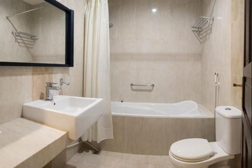 a bathroom with a sink and a toilet and a bath tub at Oak Lawang in Lawang