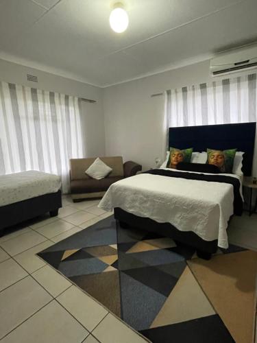 a bedroom with a large bed and a couch at 33 Boeren Guesthouse in Vryheid