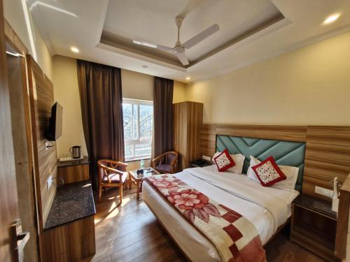 a hotel room with a bed and a television at Pinnacle Vesta Homestay in Mussoorie