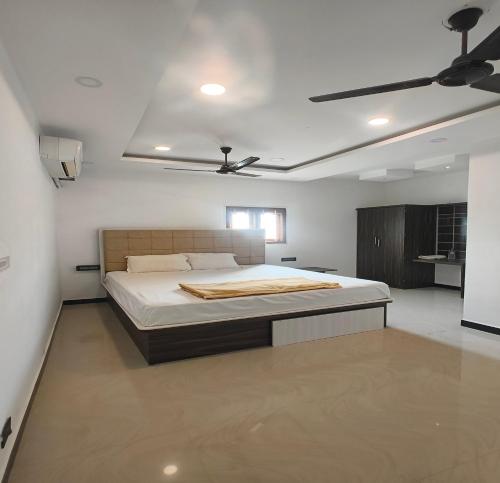 a bedroom with a bed and a ceiling fan at The Canalway Inn in Pollāchi