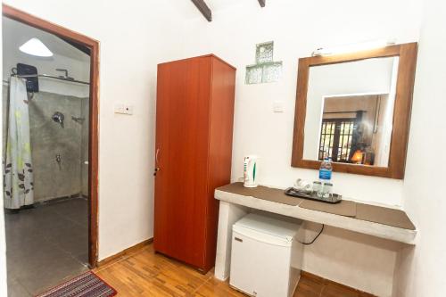 a bathroom with a sink and a mirror and a shower at Elephant Path by Alpine Resorts in Habarana
