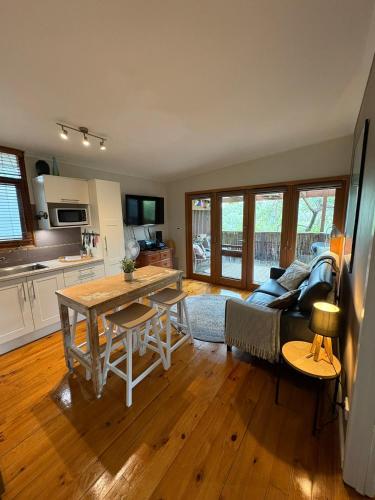 a kitchen and living room with a table and a couch at The Green Room Wattle Glen in Wattleglen