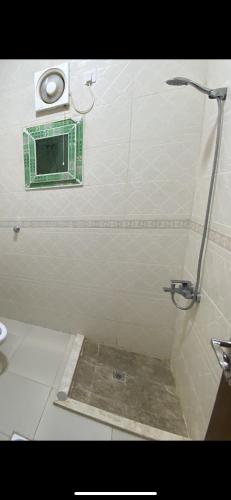 a bathroom with a shower with a window in it at مساكن بيتي in Yanbu