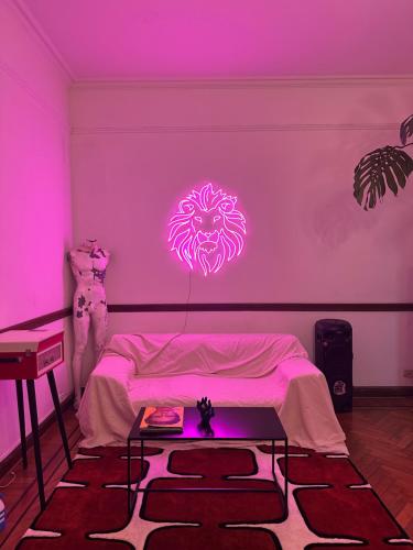 a room with a bed with a neon sign on the wall at Av corrientes 1 in Buenos Aires