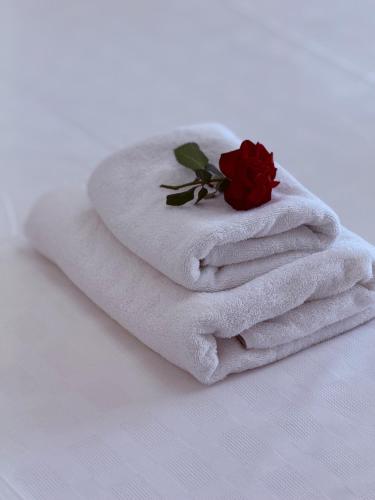 a pile of towels with a rose on top at Babis House in Pelekas