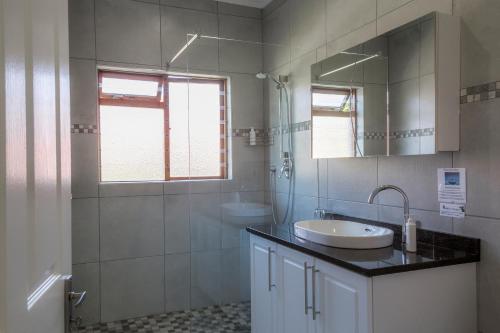 uma casa de banho com um lavatório e um espelho em Maroela House Guest Accommodation em Bellville