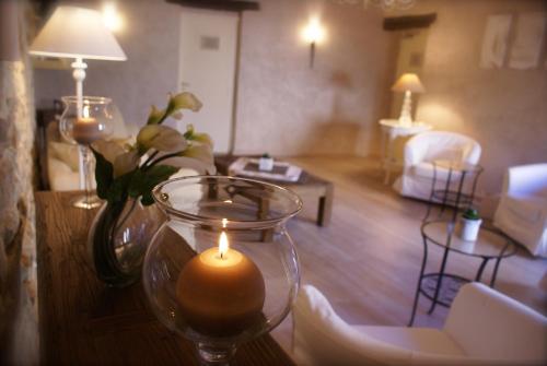a candle on a table in a living room at Le Crillon in Murs