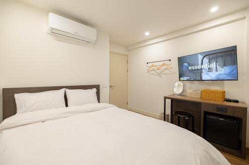 a bedroom with a white bed and a flat screen tv at 미니호텔 먹 in Seoul