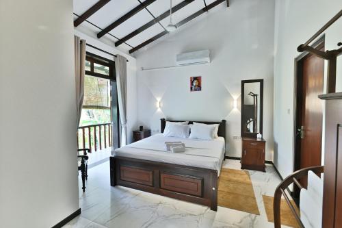 a bedroom with a bed and a balcony at Mansion view - Rose Patals in Unawatuna