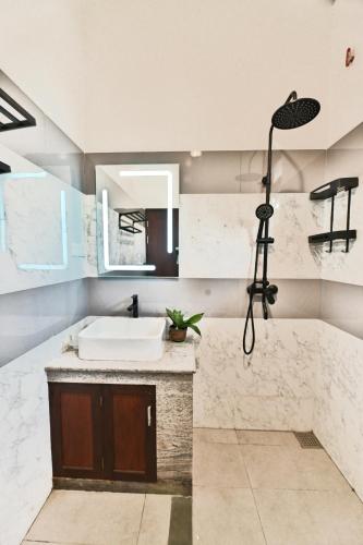 a bathroom with a sink and a mirror at Mansion view - Rose Patals in Unawatuna