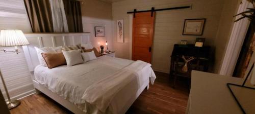 a bedroom with a white bed and a piano at Clemson Memorabilia House Frank Howard III Home in Clemson