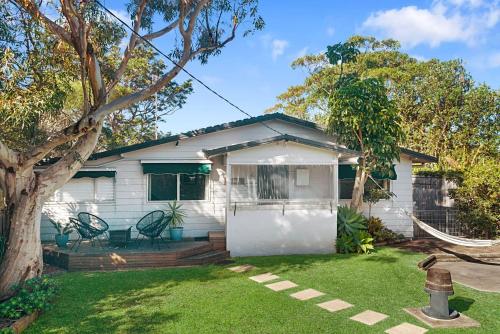a white house with a hammock in a yard at Seaward Werri Beach Gerringong in Gerringong