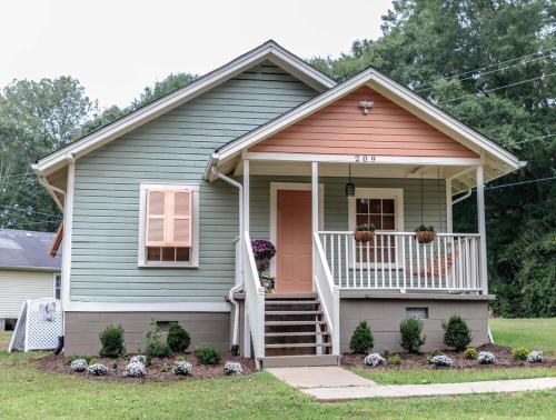 a small house with a pink door and a porch at Clemson Memorabilia House Frank Howard III Home in Clemson