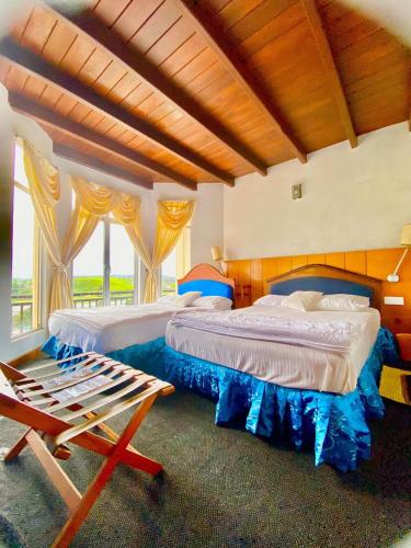a bedroom with two beds and a chair in it at Hill Paradise Nuwaraeliya in Nuwara Eliya