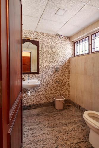 a bathroom with a toilet and a sink at Orma in Cochin