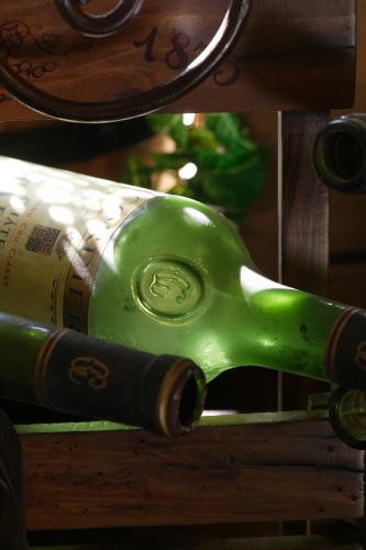 a green bottle of wine sitting on a shelf at Hotel Le Rocher Blanc in Albaret-Sainte-Marie