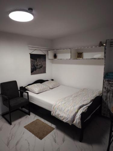 a bedroom with a bed and a chair in it at Modern lux studio B in Beringen