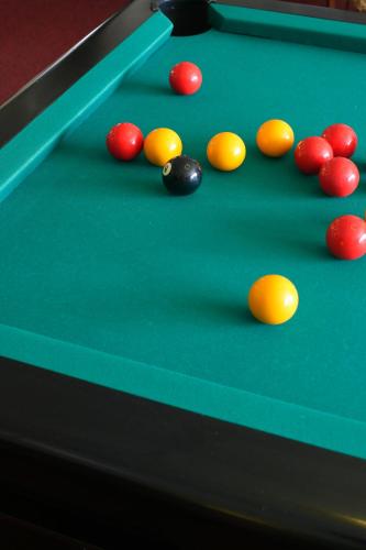 a pool table with cue balls on it at Hotel Le Rocher Blanc in Albaret-Sainte-Marie