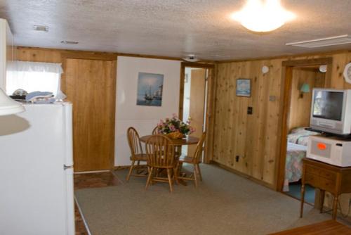 a kitchen and dining room with a table and a refrigerator at Outer Banks Motel in Buxton
