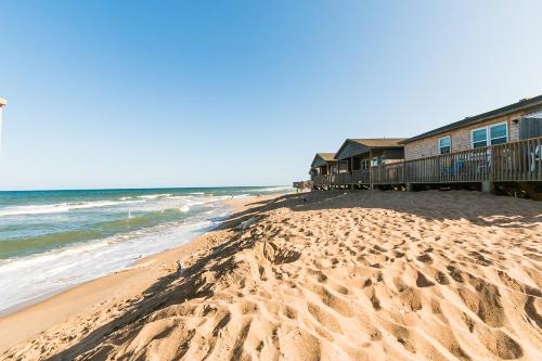 a beach with a building and the ocean at Outer Banks Motel in Buxton