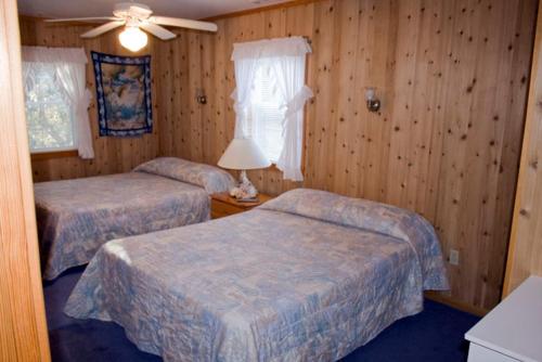 a bedroom with two beds and a ceiling fan at Outer Banks Motel in Buxton