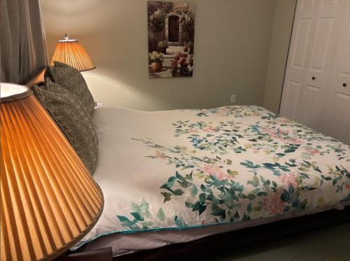 a bedroom with a bed with a floral bedspread at Sweet Home in Aldergrove