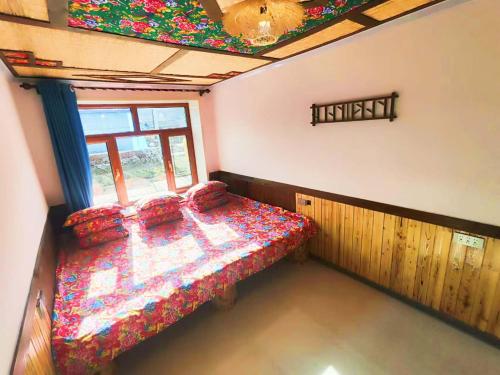a bedroom with a bed in a room with a window at Snow Valley Ma Hua Inn in Wuchang